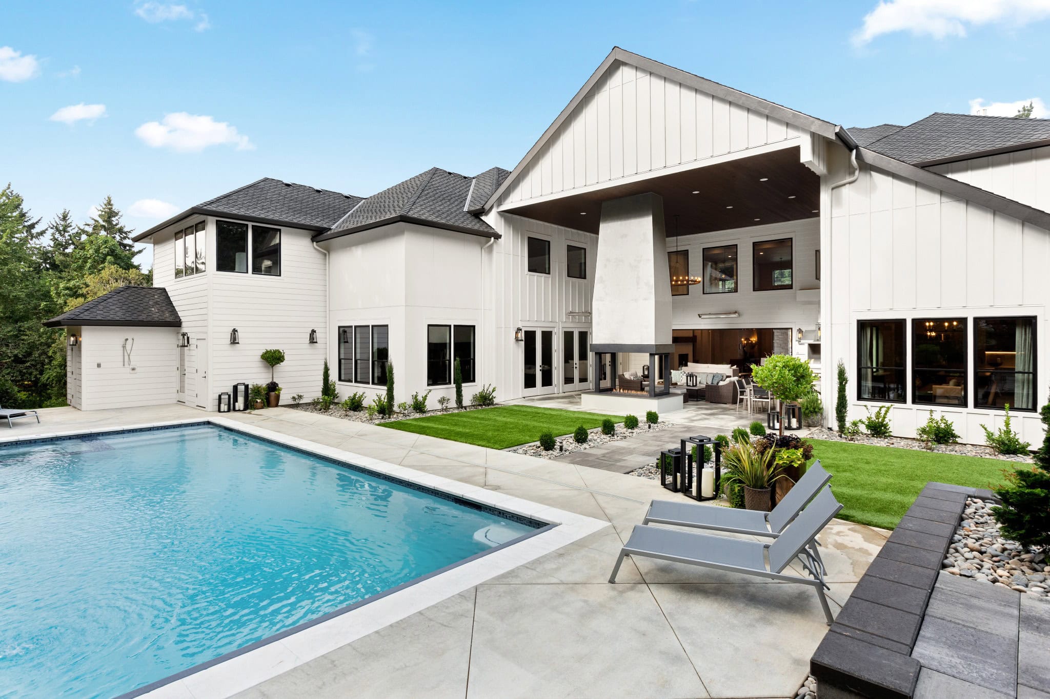 High-end outdoor kitchen and pool patio in Fairfax County with lush landscaping and modern design perfect for summer gatherings.