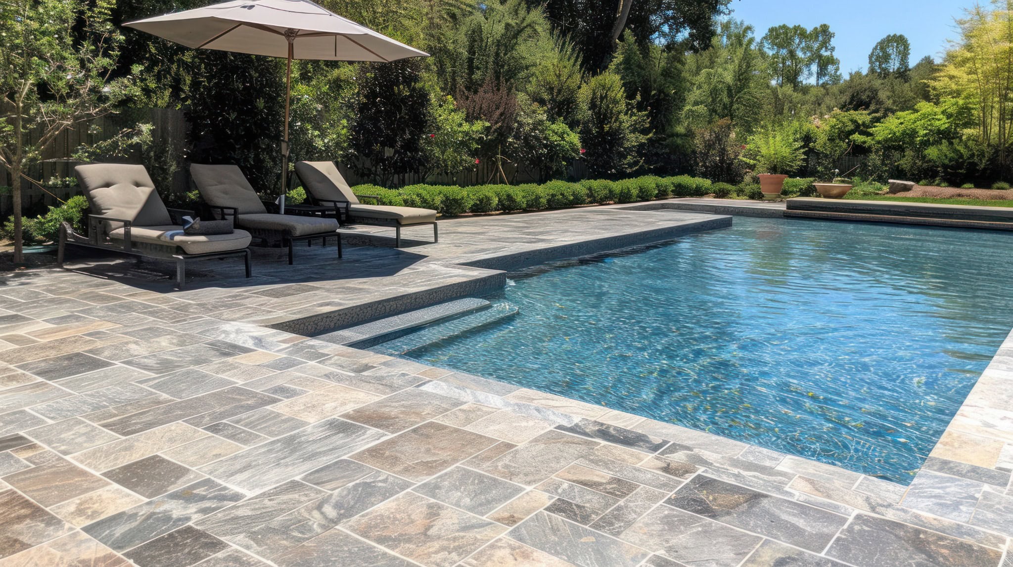 Luxury backyard pool with stone paver patio and lounge chairs in Aldie, VA.
