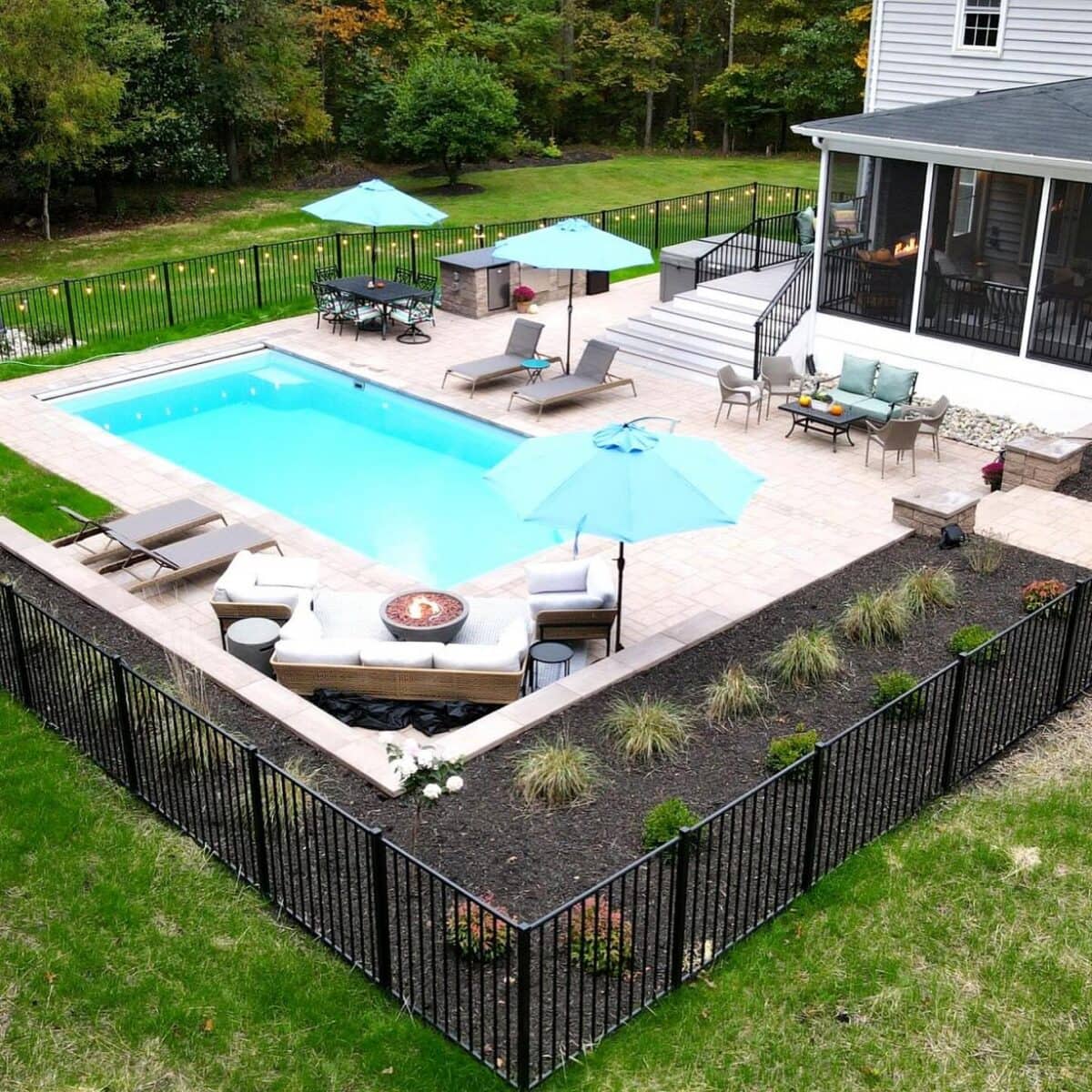 Aerial view of fenced backyard pool with umbrellas